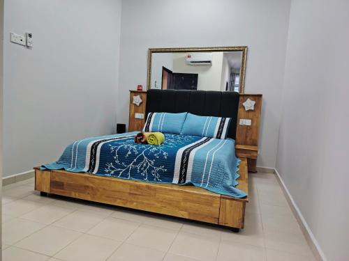 a bedroom with a bed with a mirror on the wall at Homestay Naaila, Alor Gajah in Kampong Jelatang