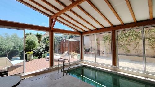 - une piscine dans une maison dotée de baies vitrées dans l'établissement Villa la Madrague vue mer, à Hyères
