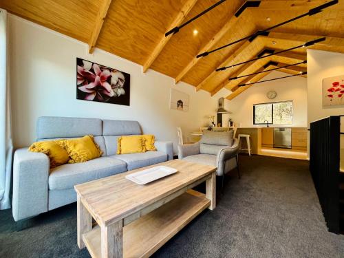 a living room with a couch and a table at Walk to Queenstown City, 30mins to Ski, Free Parking & Wifi, Gym in Queenstown