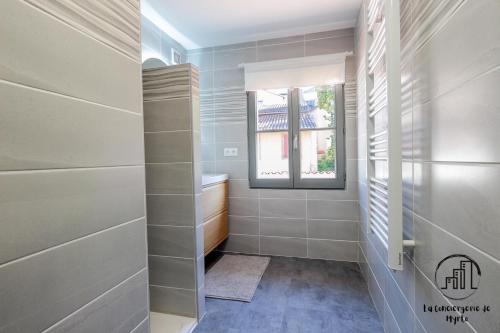 a walk in shower with a window in a bathroom at Le Nordet Vert in Albi