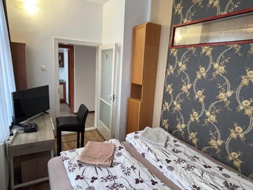 a bedroom with a bed and a desk and a computer at Centrum Vendégház in Debrecen