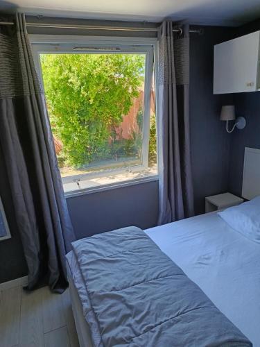a bedroom with a bed and a large window at Camping DEL MAR in Argelès-sur-Mer