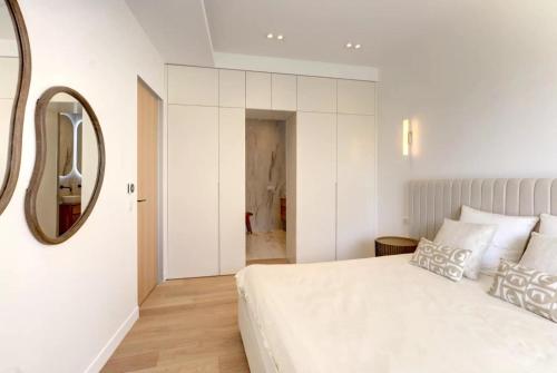 une chambre avec un grand lit blanc et un miroir dans l'établissement Luxury Apt Cannes Croisette sea view with terrasse, à Cannes