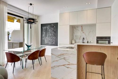 - une cuisine avec une table à manger et des chaises dans l'établissement Luxury Apt Cannes Croisette sea view with terrasse, à Cannes