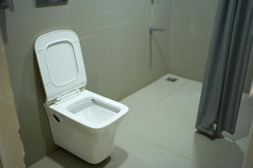 a white toilet in a bathroom with the lid up at kmslegacy in Jāmb