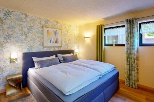 a bedroom with a large bed with a blue frame at Ferienwohnung Sächsische Schweiz Kurort Rathen in Kurort Rathen