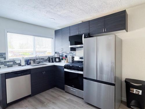 a kitchen with black cabinets and a stainless steel refrigerator at Long stay Google BBQ BIG yard in Mountain View