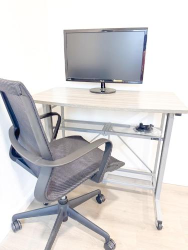 a desk with a computer monitor and a chair at Long stay Google BBQ BIG yard in Mountain View