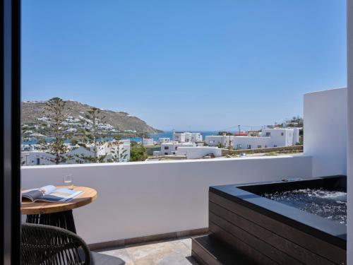 a balcony with a table and a view of a city at Kalea Mykonos in Ornos