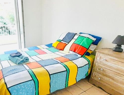 - une chambre avec un lit coloré et une commode dans l'établissement 1 chambre dans appartement 2 chambres proche mer, centre-ville et commerces, à Bastia
