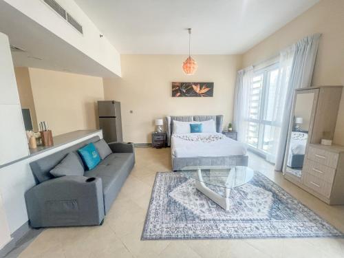 una sala de estar con un sofá y una mesa en Snug Studio With City Views, Perfect For Couples, en Dubái