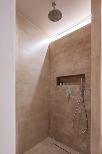 a bathroom with a shower with a shower head at Analeia Luxury Hotel - Adults Only in Kalymnos
