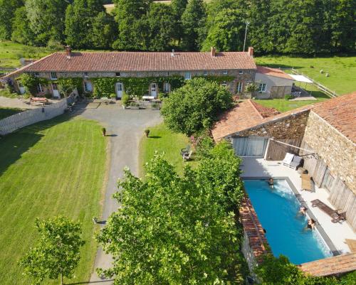 une vue aérienne d'une maison avec piscine dans l'établissement Le logis de la Grange aux Gîtes de l'Etang des Noues,, à Cholet