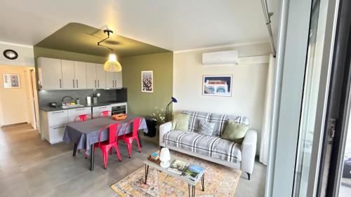 un salon avec une table et un canapé dans l'établissement 1 Chambre dans appartement neuf, terrasse sud, meublé contemporain, parking, à Aix-les-Bains