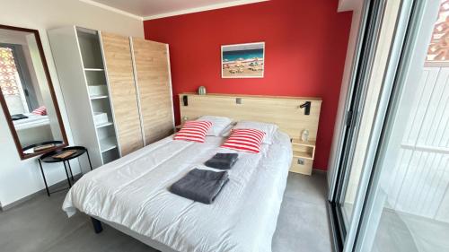 - une chambre avec un lit aux murs rouges dans l'établissement 1 Chambre dans appartement neuf, terrasse sud, meublé contemporain, parking, à Aix-les-Bains