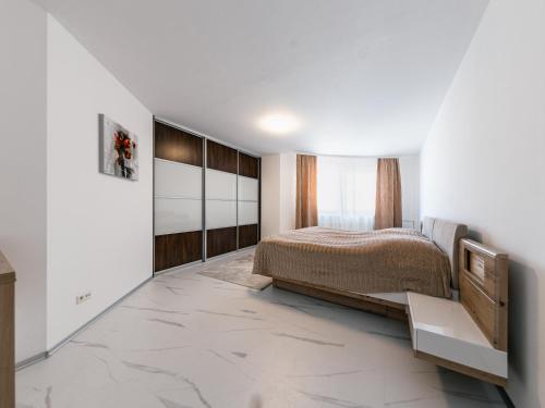 a bedroom with a bed and a white wall at Apartmán Belezza - priamo v centre in Liptovský Mikuláš