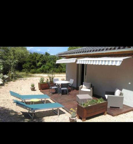 un patio avec une table, des chaises et un parasol dans l'établissement Charmant logement, à Pianottoli-Caldarello
