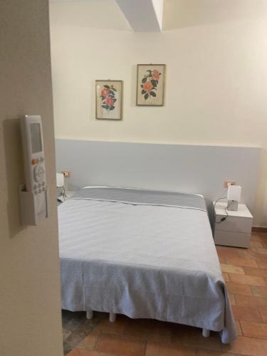 a bed in a room with two pictures on the wall at Bellavista Rooms in Villasimius