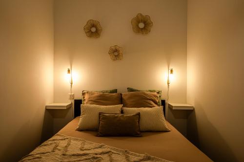 a bedroom with a bed with two mirrors on the wall at L'Appart Central - Chic et Confort in Narbonne