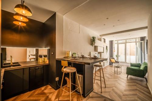 une cuisine avec un bar et un salon dans l'établissement L'Appart Central - Chic et Confort, à Narbonne