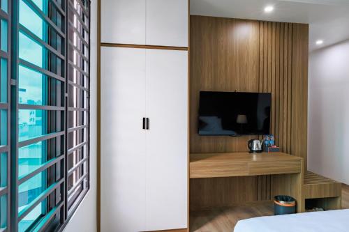 a room with a bed and a tv and a window at New Sun Móng Cái Hotel in Móng Cái