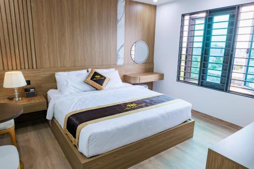 a bedroom with a large bed and a table at New Sun Móng Cái Hotel in Móng Cái