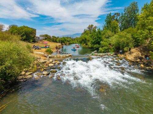 a river with rapids and people in boats on it at איילת השחר אירוח גלילי - Ayelet Hotel in Ayelet HaShahar