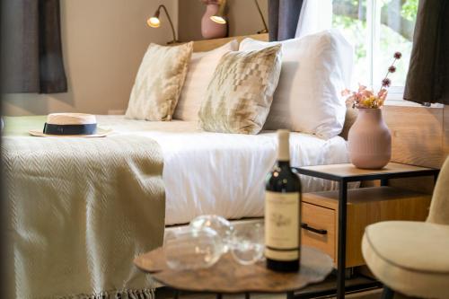 a bed with a bottle of wine on a table at איילת השחר אירוח גלילי - Ayelet Hotel in Ayelet HaShahar