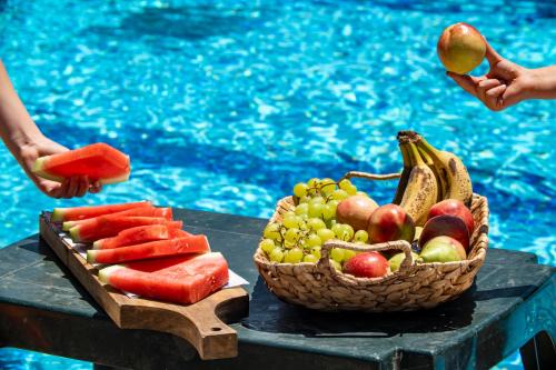 a basket of fruit on a table next to a pool at איילת השחר אירוח גלילי - Ayelet Hotel in Ayelet HaShahar