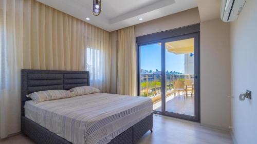 a bedroom with a large bed and a balcony at SUNSHINE VILLALAR in Belek