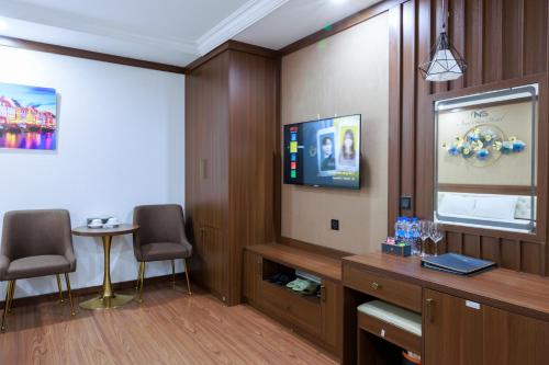 a room with two chairs and a flat screen tv at New Sun Móng Cái Hotel in Móng Cái