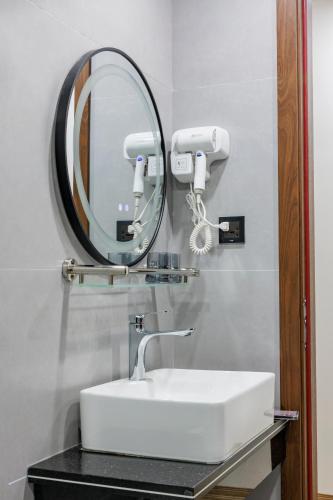a bathroom with a sink and a mirror at New Sun Móng Cái Hotel in Móng Cái