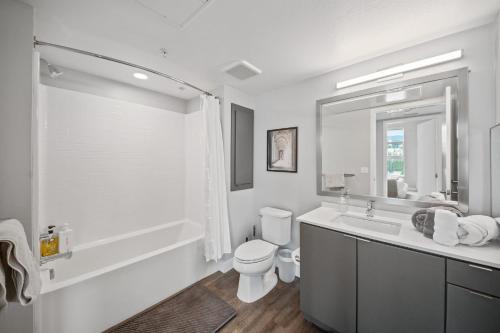 a white bathroom with a toilet and a sink at Modern Luxury Oasis in WEHO Hollywood Sign Views in Los Angeles