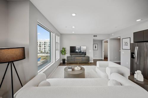a living room with white furniture and a large window at Modern Luxury Oasis in WEHO Hollywood Sign Views in Los Angeles