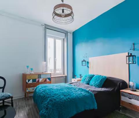 - une chambre bleue avec un lit et un mur bleu dans l'établissement Charmant cocon tout équipé, à Clermont-Ferrand