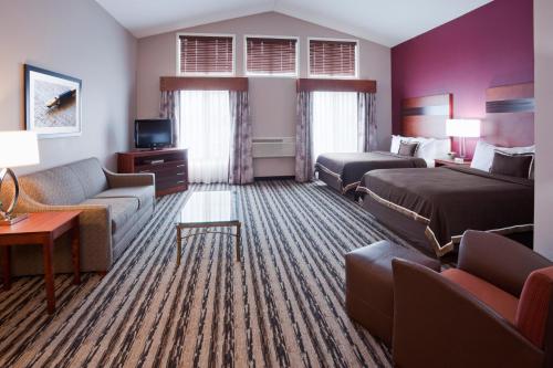 a hotel room with two beds and a couch at GrandStay Residential Suites Hotel in Saint Cloud