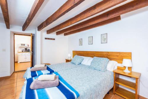 a bedroom with a large bed with blue and white sheets at Cana Can in Pollença