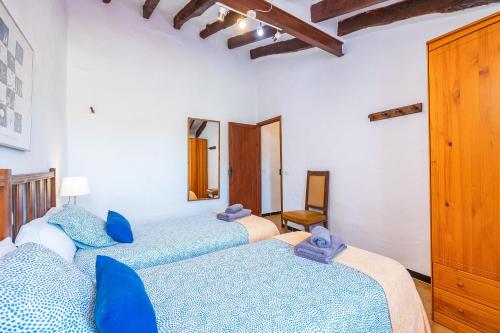 a bedroom with two beds with blue pillows at Cana Can in Pollença