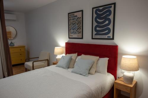 a bedroom with a bed and two lamps and a chair at Apartamentos "El Aljibe" - Parking incluido in Badajoz