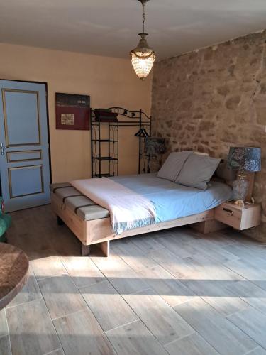 une chambre avec un lit et un mur en pierre dans l'établissement Chambre d'hôte Moulin du Breuil., à Pionnat