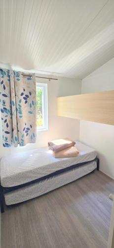 - une petite chambre avec un lit et une fenêtre dans l'établissement Bungalow-Mobilhome - Petit prix- Océan -Forêt -Camping 3 étoiles, à Bias