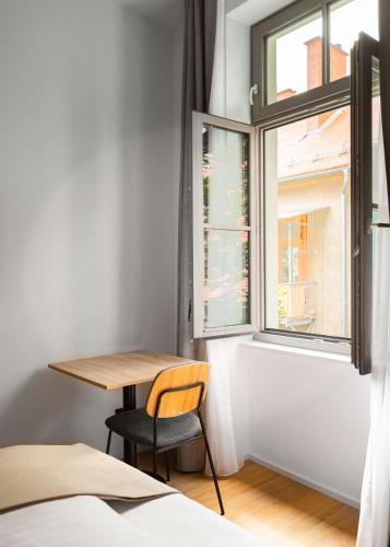 a table and a chair in a room with a window at Limehome Graz Trauttmansdorffgasse in Graz
