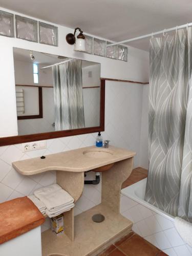 a bathroom with a sink and a mirror and a tub at Casas La Pequeña Lulu in Los Caños de Meca