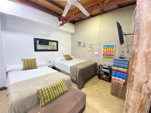 Habitación con 2 camas, TV y silla. en Apartarstudio muy bien ubicado, cercano a todo!!, en Cali