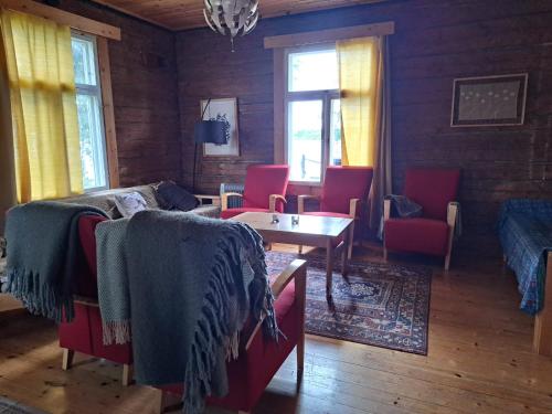 a room with a bed and chairs and a table at Rantasauna, Villa Mainiemi in Hämeenlinna