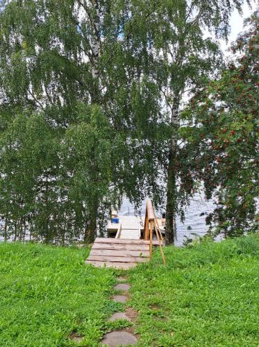 a wooden dock with a bench next to a lake at Rantasauna, Villa Mainiemi in Hämeenlinna