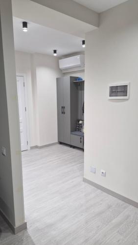 an empty room with white walls and wood floors at Жуляны in Chişinău