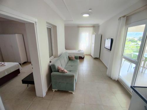 a large living room with a couch and a bed at Bucak Apart Hotel Göcek & Beach in Göcek