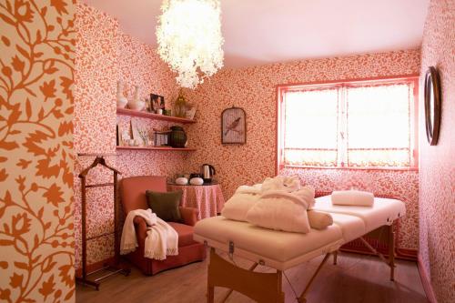 a pink room with a bed and a chair at CAZAUDEHORE Hôtel Restaurant Gastronomique Terrasse et Jardins in Saint-Germain-en-Laye