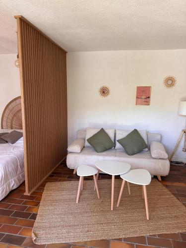 - un salon avec un canapé, deux tables et un lit dans l'établissement Studio 3 mn de la mer -Proche Sablettes, à La Seyne-sur-Mer